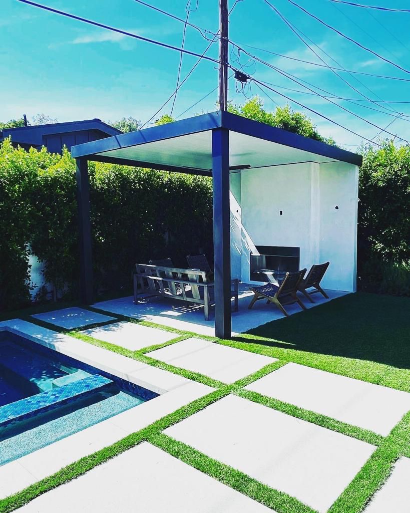 Modern outdoor seating area beside pool with concrete pavers.